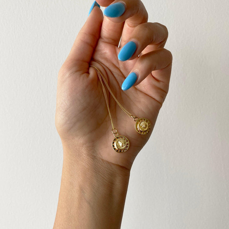 Sun And Moon Necklace Held By A Woman